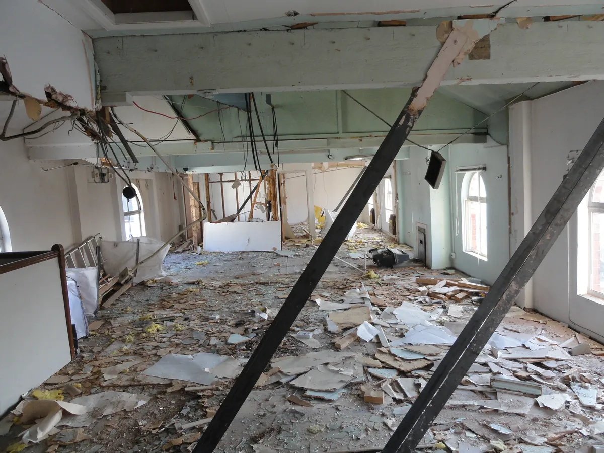 Interior of a long-vacant commercial building on acquisition, stripped back with props in place