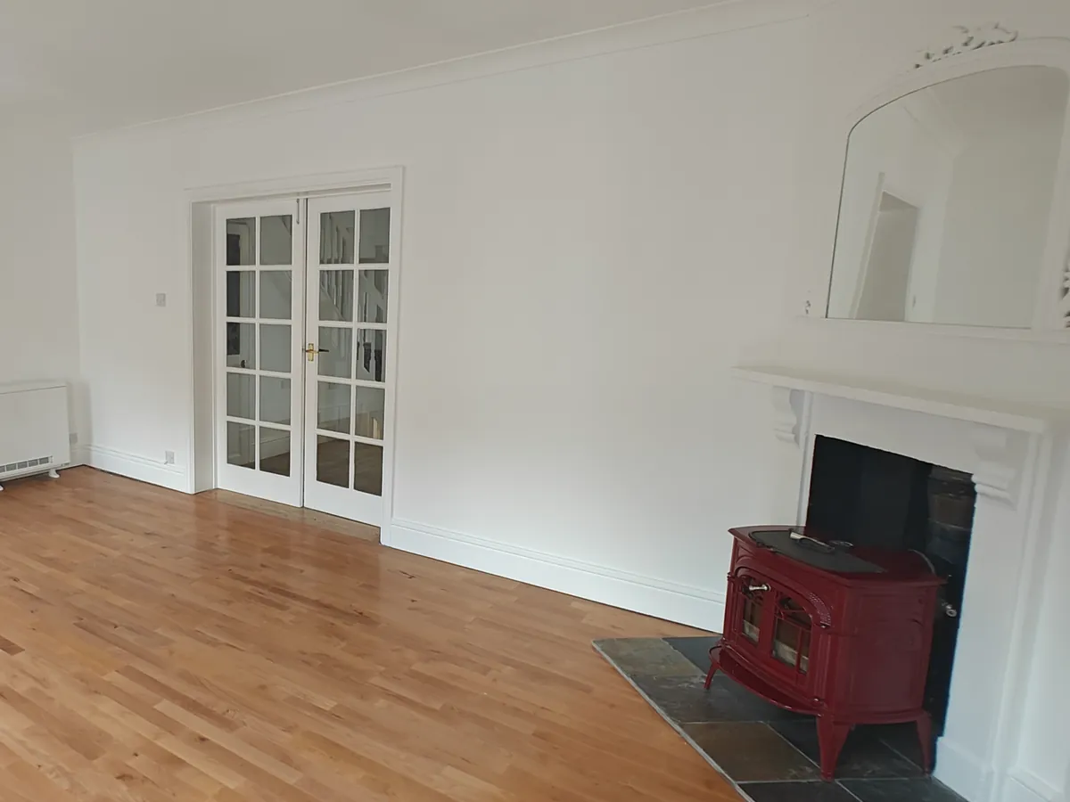 Refurbished residential living room with fireplace and wood-burning stove