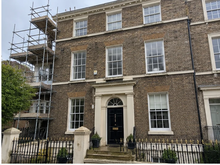 Georgian brick townhouse with fanlight doorway and scaffolding during works