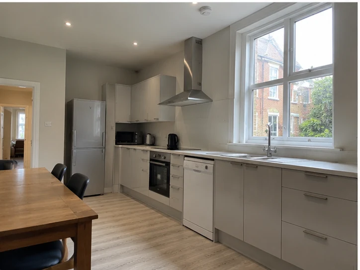 Refurbished shared-house kitchen with modern units and sash window